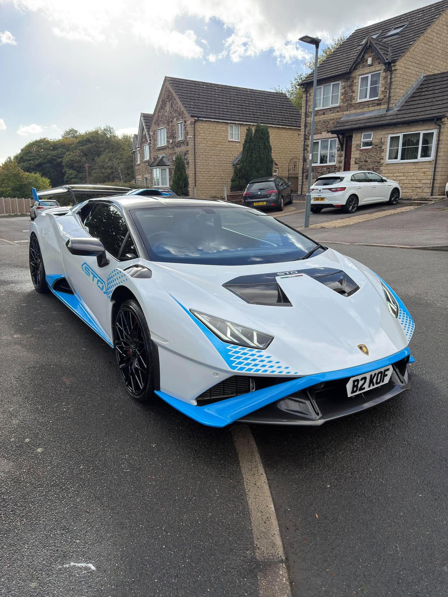 Front three-quarter view of a white and blue Lamborghini Huracán STO after exterior detailing